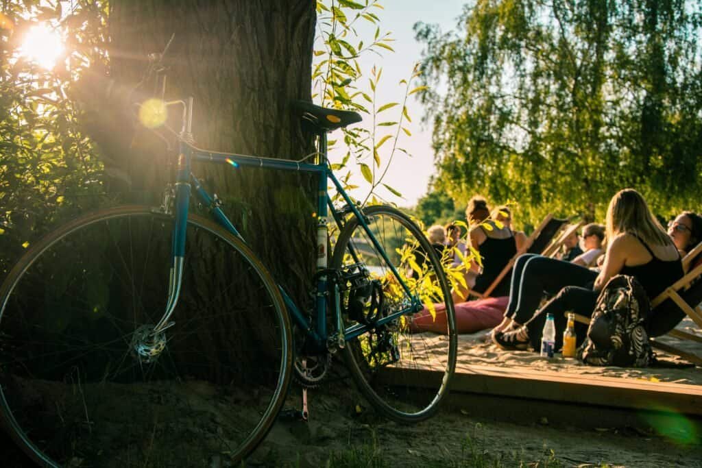 Vélo posé contre un arbre lors d’un atelier de coaching en plein air, ambiance conviviale et détendue.
